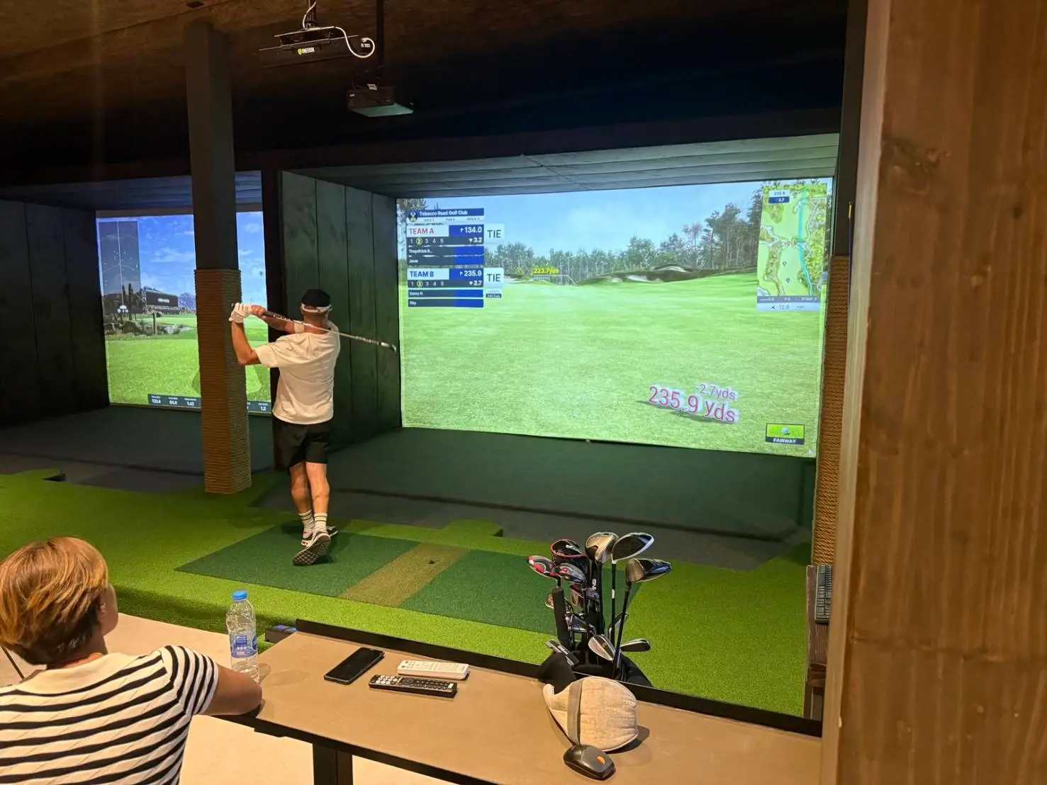Golf simulator bay with lush greenery